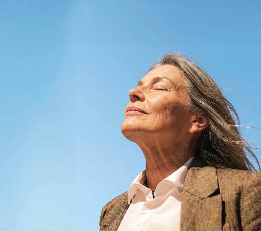 Femme sereine, visage tourné vers le ciel